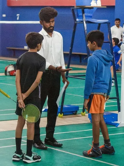 An umpire gives instructions to two young players before their match begins, highlighting our focus on fair play and official rules even at the junior level.