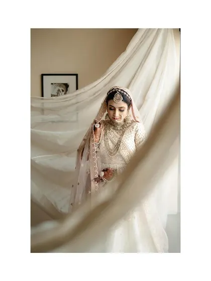 A beautiful portrait of the bride, with the light catching the sheer fabric of her veil, creating a soft and dreamy effect.
