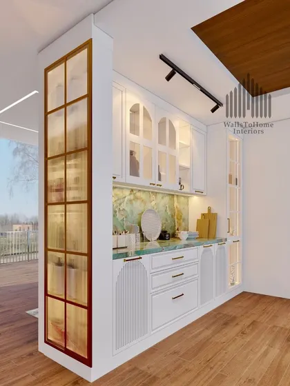A stunning crockery unit design with a green onyx marble countertop and backsplash, white fluted cabinets, and gold-framed glass doors.
