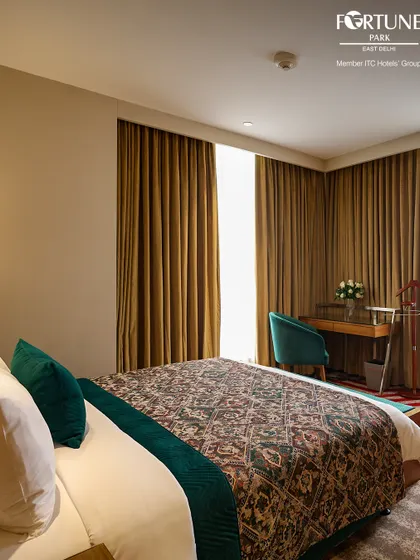 This room features a stylish patterned bedspread and a work desk by the window. It’s a quiet and comfortable space designed for both productivity and relaxation.