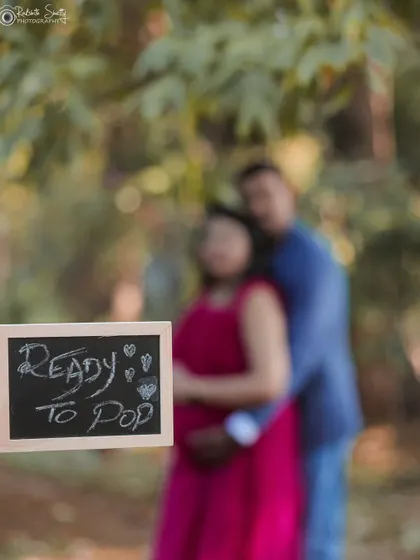 "Ready to Pop" says it all. This fun shot uses a chalkboard sign and selective focus to create a playful and artistic pregnancy announcement.