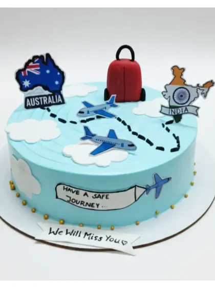 A travel-themed farewell cake for someone moving from India to Australia. This fresh strawberry cake features airplanes, clouds, and maps to wish them a safe journey.