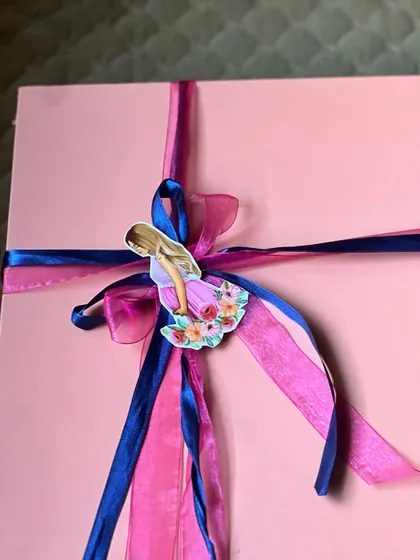 The exterior of the pink trunk box, carefully wrapped with pink and blue ribbons. The presentation is just as important as the gifts inside.