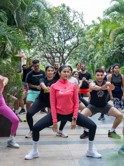 Leading a group in a synchronized squat move. These collective movements are great for building a sense of unity and teamwork.