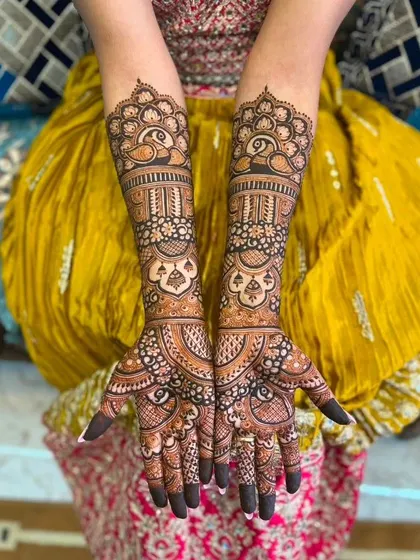 Symmetrical peacock designs on both arms, with intricate bands and patterns creating a full and rich bridal mehandi.