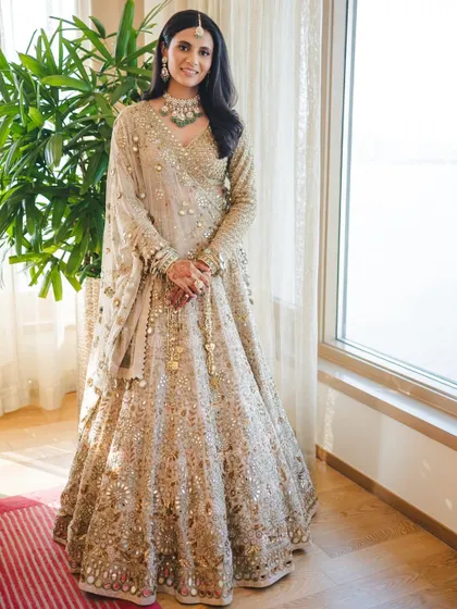 A full-length view of this bride's quiet elegance. Her minimal, refined glam in a beige Arpita Mehta lehenga is perfect for the modern bride who loves understated beauty.