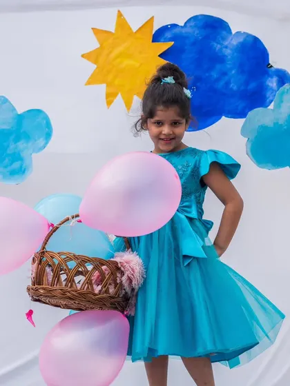 A vision in turquoise blue. This elegant party dress features a full tulle skirt and delicate flutter sleeves, creating a dreamy, ethereal look for your little one.