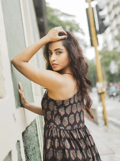 A close-up street portrait, using the texture of the wall and the natural city light to frame the subject.