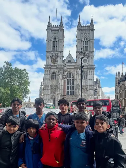 A group photo in front of the historic Westminster Abbey in London.