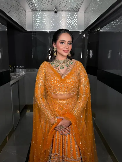A full-length shot of the Roka bride, showcasing her beautiful orange lehenga and our matching jewellery.