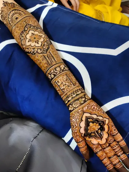 A close-up of a stunning bridal design, featuring a lotus motif on the palm and intricate patterns on the arm.