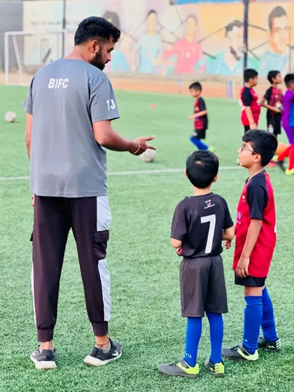 A mentor by their side. A coach gives instructions to our youngest players, guiding them on their first steps in their football adventure.