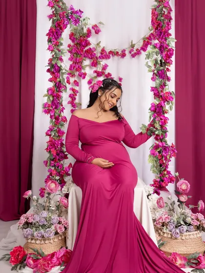 Seated amongst a garden of flowers, this mom-to-be looks like a goddess of spring in this colorful studio setup.