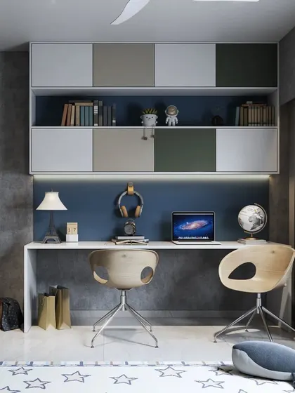 A shared study space for two, with a long, clean-lined desk and individual chairs. The overhead cabinets in shades of blue and green add storage and color.