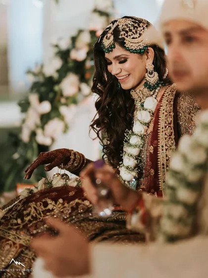 A happy, candid moment during the wedding rituals. Her smile and glowing makeup light up the photo.