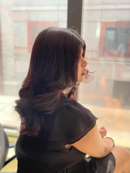A candid shot of a model with a freshly styled haircut, featuring layers and soft curls that frame the face beautifully.