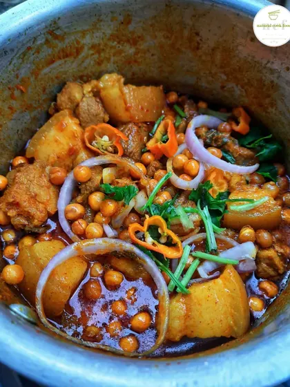 My NCF pork mixture, a savory dish with potatoes and chickpeas, garnished with fresh onion and chillies.