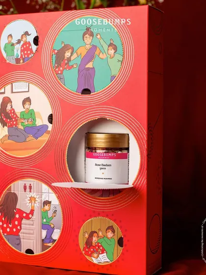 Behind every illustration is a delicious surprise. Here, a jar of Rose Badam Mukhwas is unveiled, adding another layer of delight to the unboxing experience.
