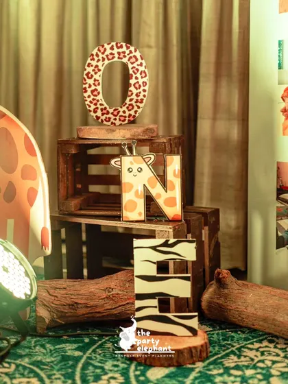 A creative way to display the number 'ONE' for a first birthday, with each letter decorated in a different animal print like leopard, giraffe, and zebra.