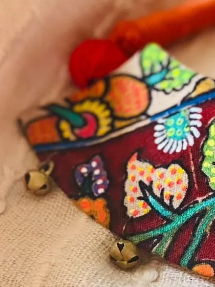 A close-up shot of a hand-painted fabric piece, showing the fine details and tiny ghungroo bells that I add for a delicate, musical touch.