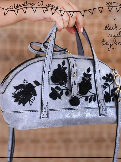 The Tiny Mandy bag in our Black Lace Crystal edit. The intricate black floral embroidery creates a dramatic contrast against the shimmering, distressed silver-tone Crystal leather, which is now a sold-out favorite.