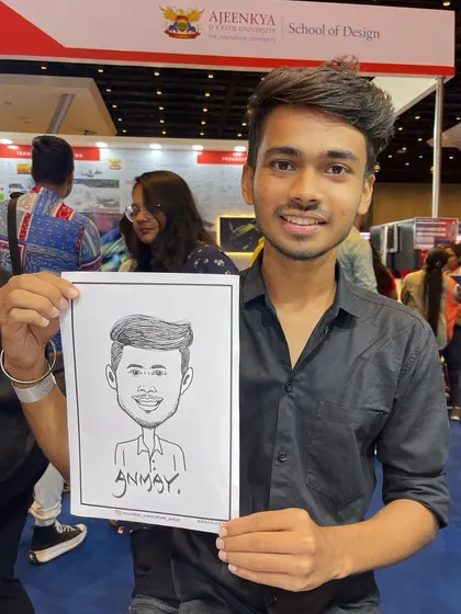 A young man with his caricature at an education fair booth for Ajeenkya DY Patil University. It's an effective way to attract students to your stall.