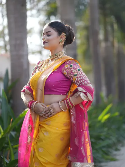 A side view highlighting the detailed embroidery on the blouse and the traditional Maharashtrian ear cuff, known as a 'kaan'.