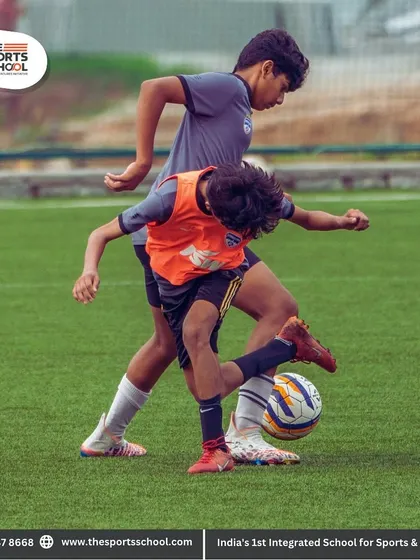 A physical battle for ball possession between two young players, showing the competitive spirit nurtured in our training sessions.