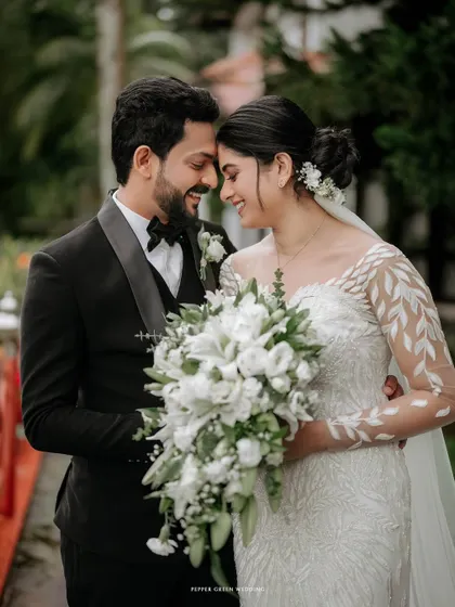 A beautiful close-up of the bride and groom, their heads together, sharing a quiet, happy moment. The intricate details of her dress and the soft bouquet add to the romance.