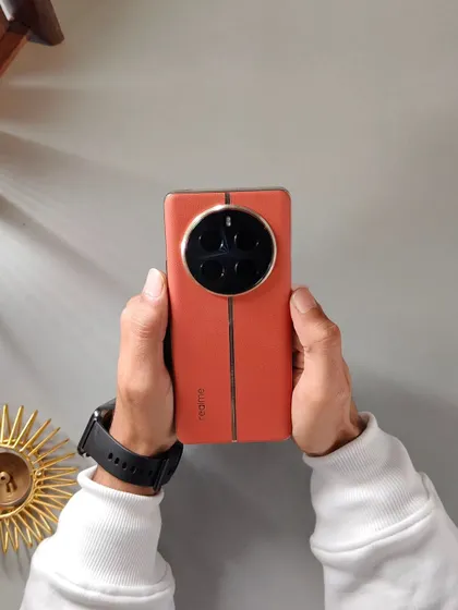 This flat-lay inspired shot showcases the back of the Realme 12 Pro+ against a textured background, highlighting its unique camera design and color.