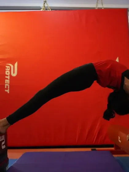 This gymnast demonstrates incredible flexibility and strength in a bridge pose supported by equipment. Our program focuses on developing the core strength necessary for advanced gymnastic movements.