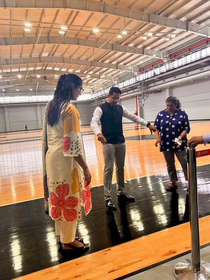 Visitors touring our NBA-grade basketball court, experiencing the professional quality of the imported American hardwood floor firsthand.