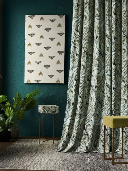 A moody interior shot for a forest-themed collection. The moth-print artwork and marbled green curtain create a mysterious and sophisticated atmosphere, inspired by the secrets of nature.
