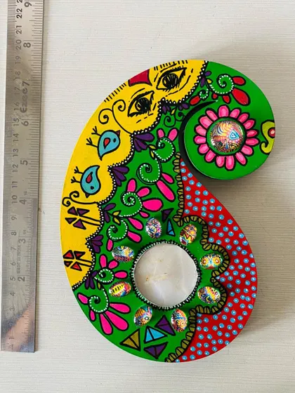 This paisley candle holder features a playful design with eyes and little birds. It’s a quirky and unique piece to light up your space.