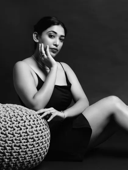 A seated black and white portrait that plays with shadows and form. The composition is simple yet powerful, focusing on the model's elegant posture.