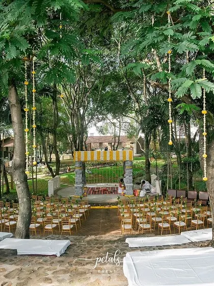 The natural beauty of Angana the Courtyard is the perfect canvas for a temple-themed wedding. Here, floral garlands hang from the trees, creating a magical, immersive experience for guests as they approach the mandap.
