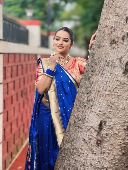 A candid shot of a model in a royal blue Nauvari saree. The makeup is kept subtle to let the vibrant color of the saree stand out.