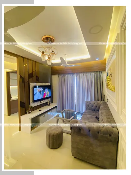 Another angle of the living room in Majestic Villa, Dronagiri. This view shows the TV unit, the false ceiling design with ambient lighting, and the overall color palette that creates a cohesive and modern look.