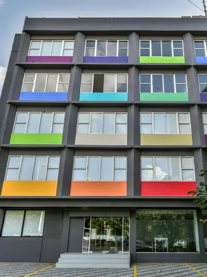 An example of adaptive reuse architecture. We converted a drab, old hotel building into a vibrant co-working space by giving the facade a modern grey finish and adding pops of color.