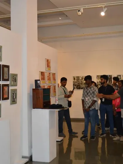 A faculty member photographs his students as they interact with the exhibition, capturing their engagement.