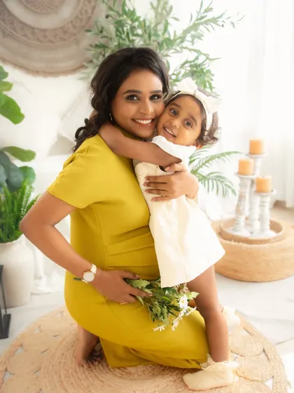 A mother and daughter share a warm embrace. This photo, taken during a maternity session, beautifully captures the existing bond before a new baby arrives.