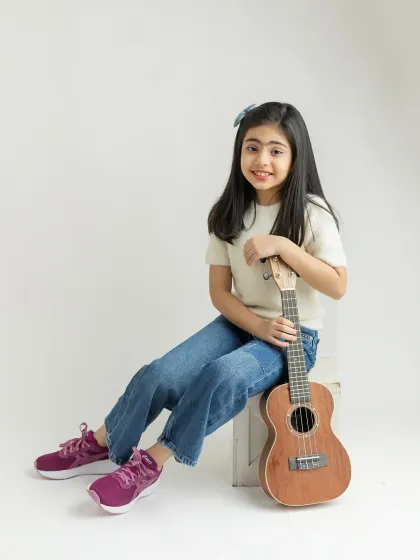 A classic, smiling portrait with her ukulele. She looks so natural and happy.