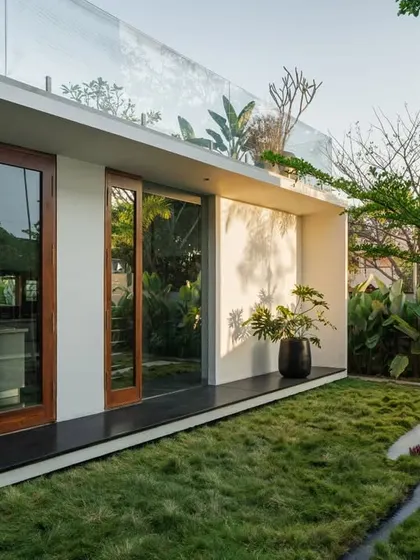 The Long House features a seamless transition from the interior to the lawn, with large glass doors and a continuous ground plane.