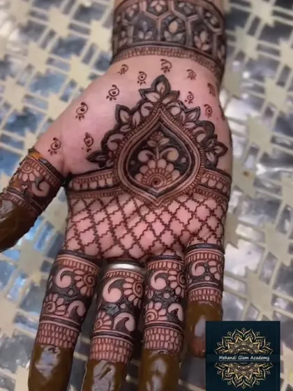 This design features a bold, symmetrical motif in the center of the palm, surrounded by a net pattern. The dark, filled fingertips provide a classic bridal finish.
