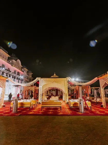 A wide shot of the royal wedding setup at night, with golden-domed canopies and a rich red carpet creating a truly regal ambiance at The Leela Palace.