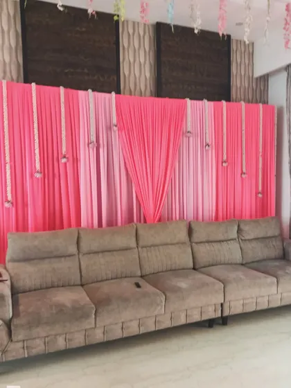 A simple and effective backdrop for a home function. I used pink drapes and hanging jasmine flower strings to create a designated photo area.