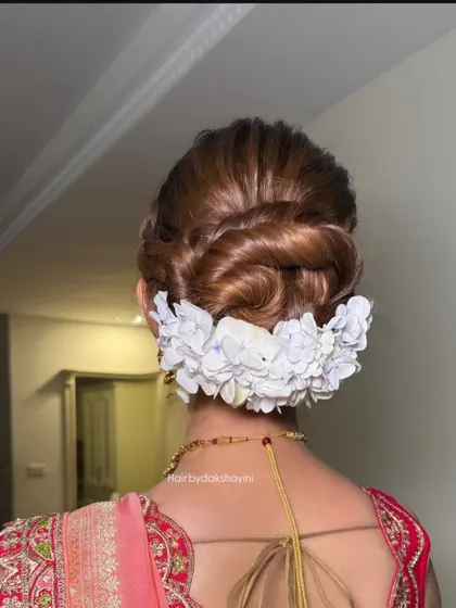 A close up of the intricate braided bun with white flowers, showing the texture and detail.