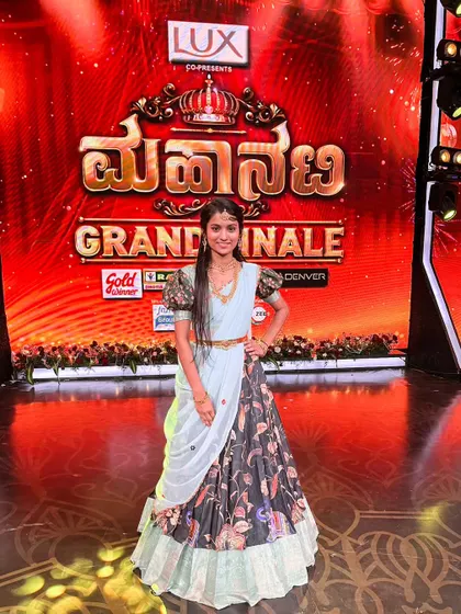 A full-length view of the antique jewellery set, showing how it pairs beautifully with a modern half-saree for a stage performance.