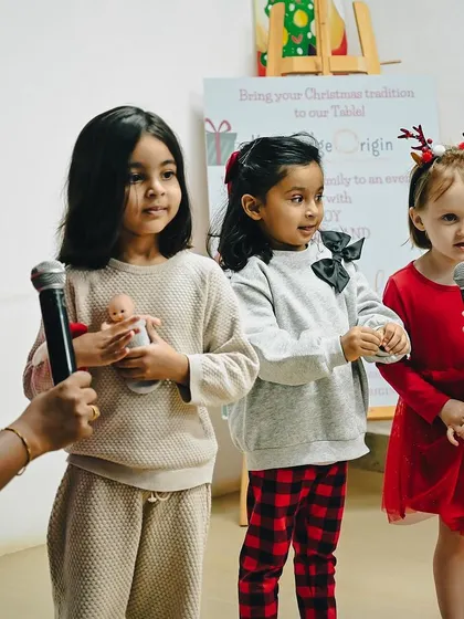 Three children bravely take the microphone to sing a Christmas carol for their parents.
