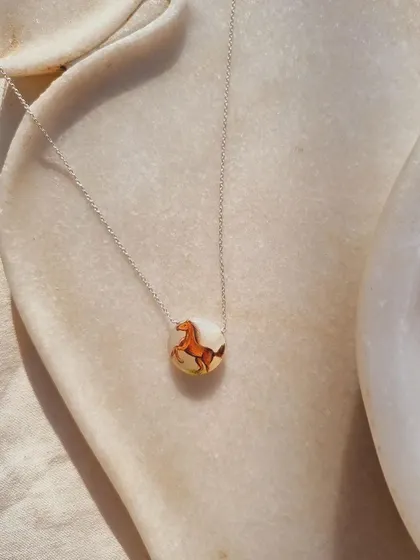 This is 'Oliver's horse', a hand-painted talisman on a White Moonstone pendant. Moonstone is a stone for emotional stability and new beginnings.